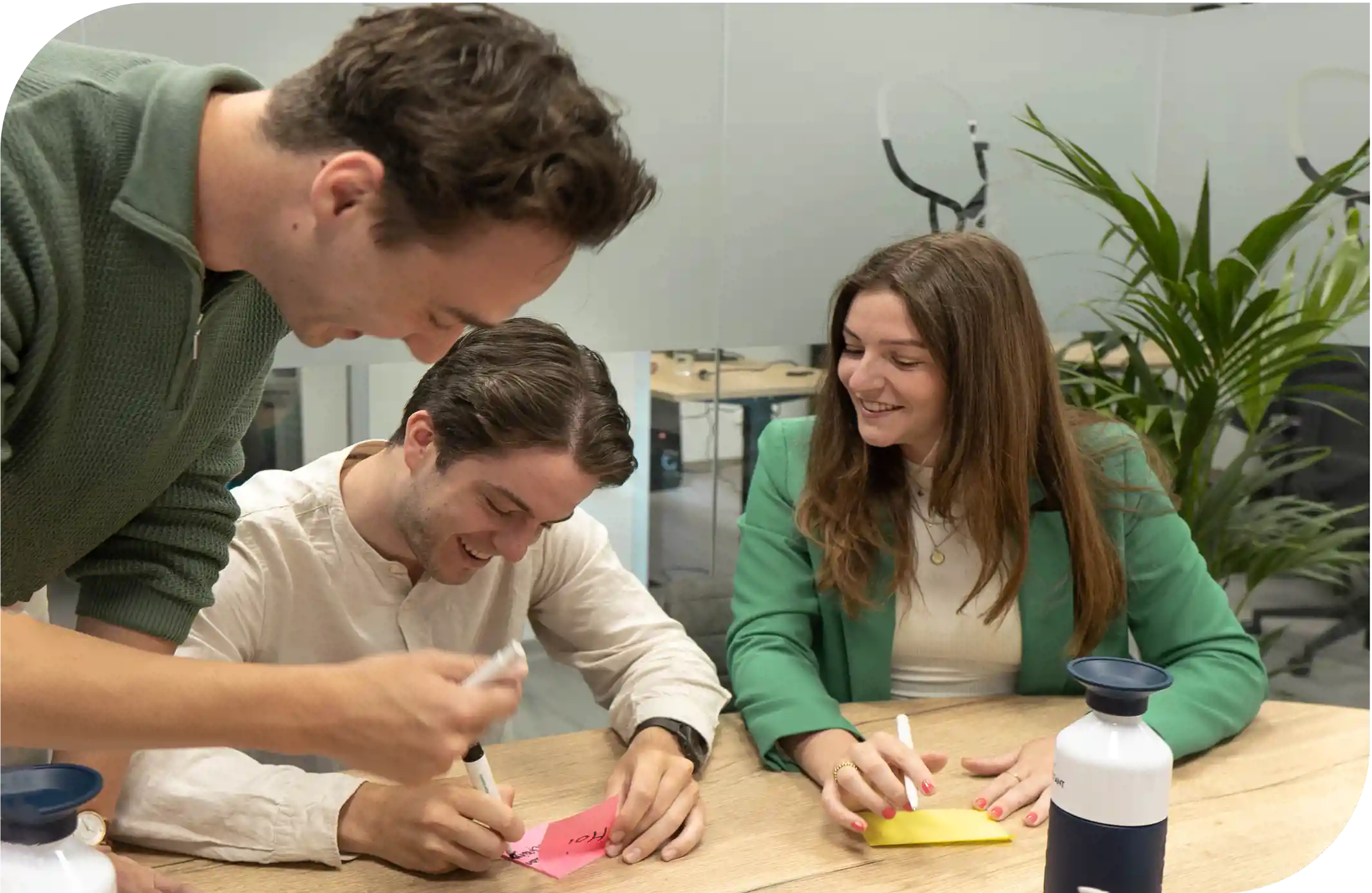 Drie Student Consultants brainstormen aan tafel op het hoofdkantoor in Tilburg